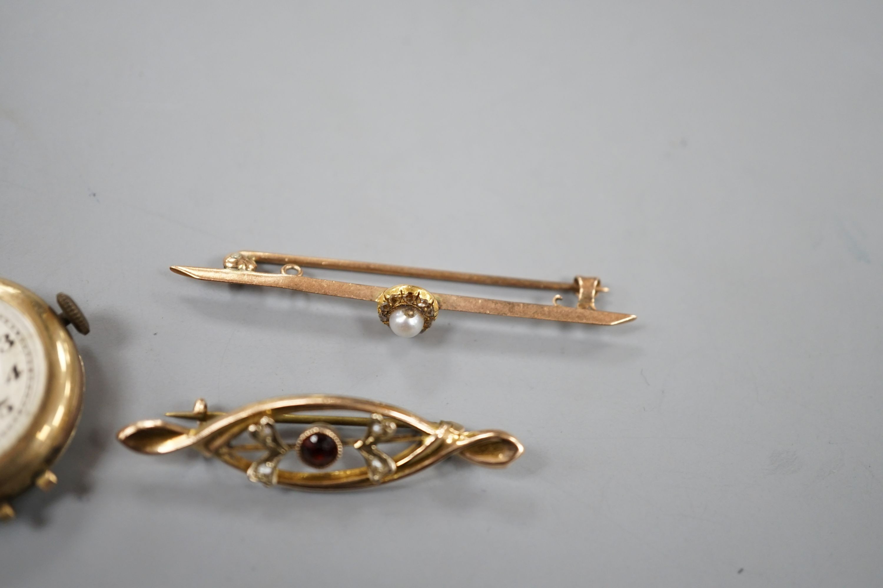 Two early 20th century 9ct and gem set bar brooches and a lady's 9ct manual wind wrist watch, no strap